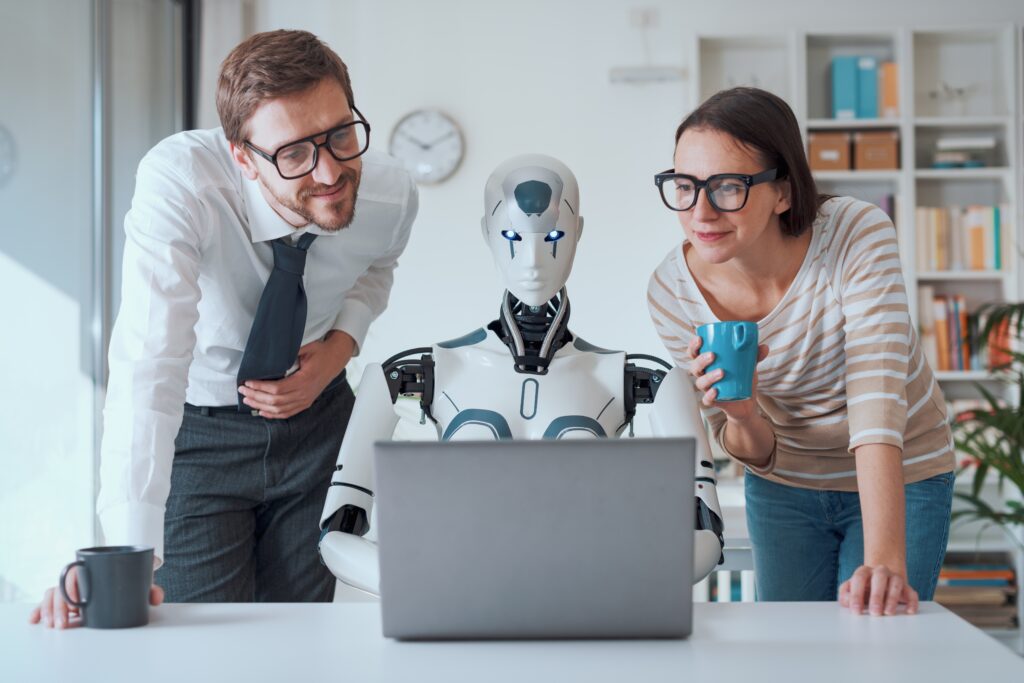 Einsatz von KI im Unternehmen, Personen und Roboter vor Bildschirm, Shutterstock / Stock-Asso